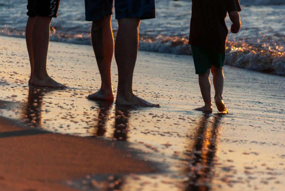 family enjoying a sunset walk on beach