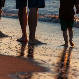 family enjoying a sunset walk on beach