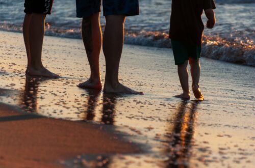 family enjoying a sunset walk on beach
