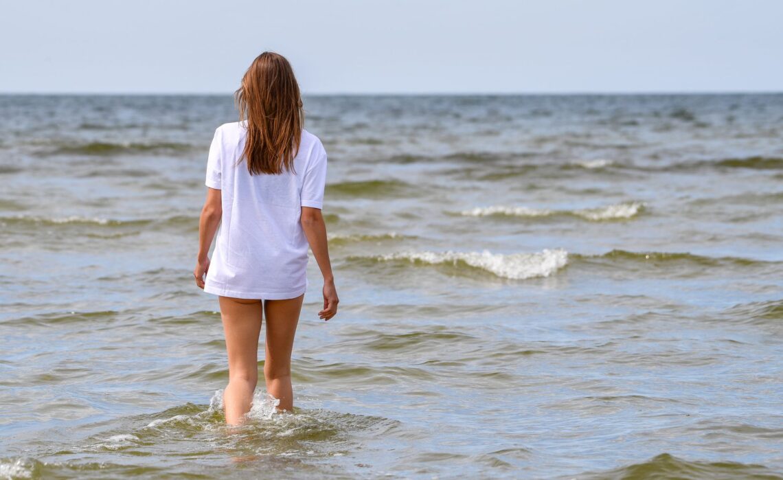young woman walking in the sea at kloogaranna