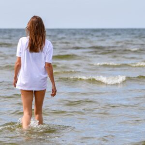 young woman walking in the sea at kloogaranna